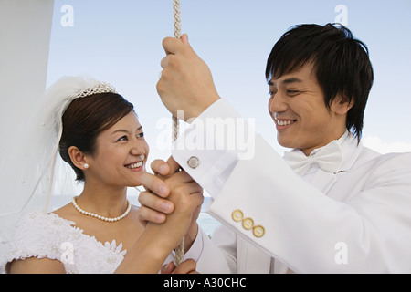 Bride and groom ringing church bell Stock Photo