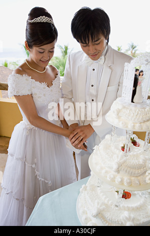 Bride and groom cutting wedding cake Stock Photo