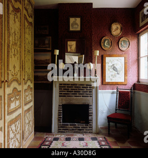 Chair at brick fireplace in room with painted wardrobe Stock Photo