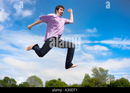 Young man jumping in air, low angle view, Stock Photo