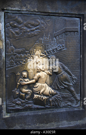 Bronze relief on the base of the statue of St John of Nepomuk shows his martyrdom when he was thrown bound gagged from the bridg Stock Photo