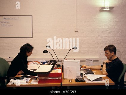 Two people at their desks in a book designers publishing company Stock Photo