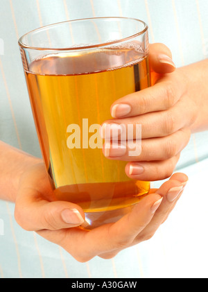 WOMAN HOLDING GLASS OF APPLE JUICE Stock Photo