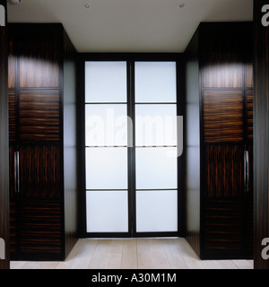 Glass double door with two polished walnut wardrobes Stock Photo