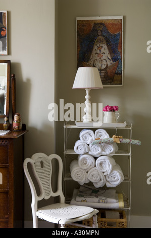 Lamp and chair with rolled towels on bathroom shelving unit Stock Photo