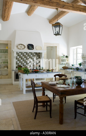 Dining table and chairs on rug in open plan kitchen Stock Photo