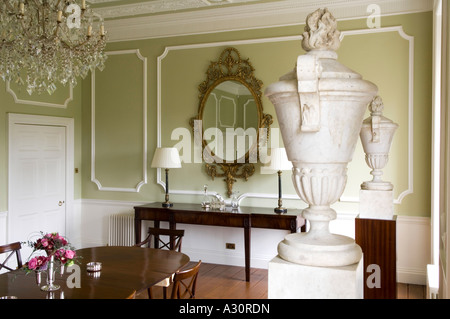 Green dining room with large ornamental vases on plinths Stock Photo