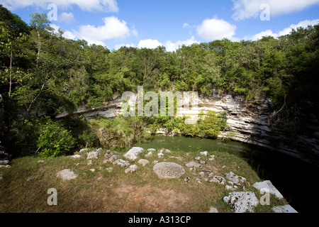 Cenote a sacred well used for human sacrifice at the ruined Mayan city of Chichen Itza in Mexico Stock Photo