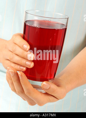WOMAN HOLDING GLASS OF POMEGRANATE JUICE Stock Photo