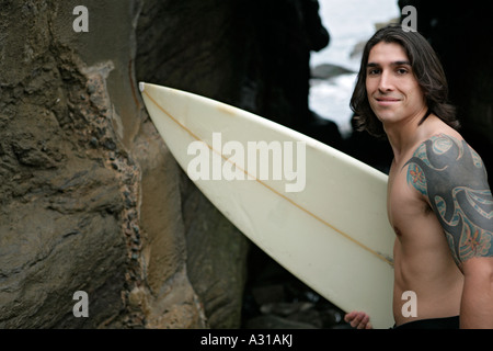 View of a man holding a surfboard. Stock Photo