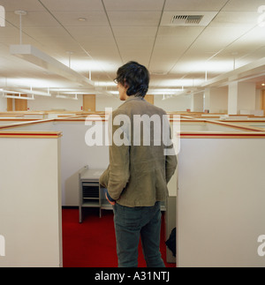 Young man looking over empty office cubicles Stock Photo