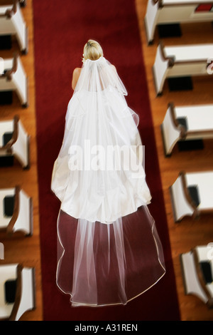 Bride walking down church aisle Stock Photo