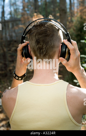 Man standing in the woods and wearing headphones Stock Photo