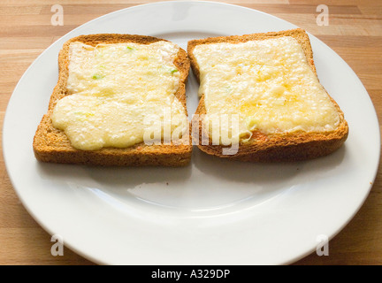 Cheese melt melted on wholemeal brown Toast bread on a plate grill grilled hot Stock Photo