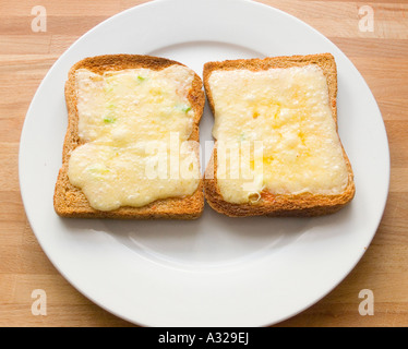 Cheese melt melted on wholemeal brown Toast bread on a plate grill grilled hot Stock Photo