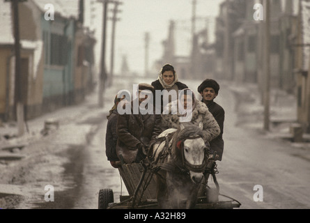 romania after the revolution men women traveling in agricultural horse drawn wagon on road covered by snow ice in the suburbs of sibiu 1990 Stock Photo