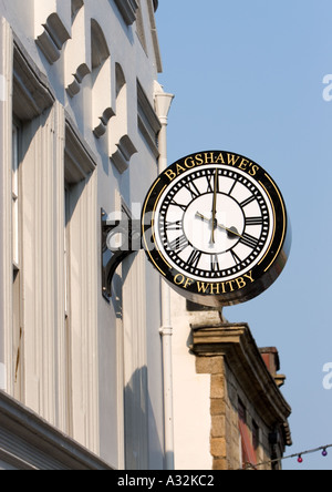 Bagshawe's of whitby exterior bracket clock, black and white with gold lettering and large clock hands, four o clock, in whitby north yorkshire uk Stock Photo