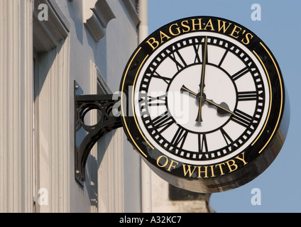 Bagshawe's of whitby exterior bracket clock, black and white with gold lettering and large clock hands, four o clock, in whitby north yorkshire uk Stock Photo