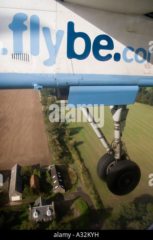 Lowered undercarriage wheel of a  Flybe de Havilland Canada DHC-8 Dash 8 approaching Edinburgh airport Stock Photo