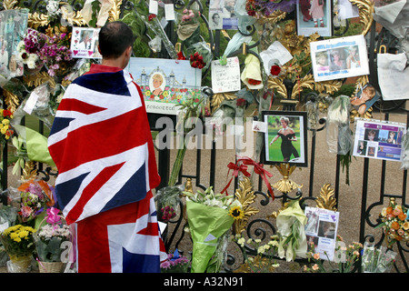 mourner wrapped in union jack looks at the messages hanging on kensington palace gates in memory of princess diana Stock Photo