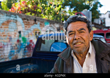MEXICO San Miguel de Allende Portrait of gray haired male Mexican auto mechanic colorful mural on wall in background Stock Photo