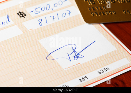 Signing a bank check on a desk Stock Photo