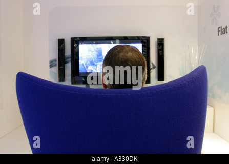 Man siting in an armchair in front of a plasma television set, Berlin, Germany Stock Photo