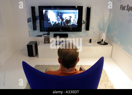 Man siting in an armchair in front of a plasma television set, Berlin, Germany Stock Photo