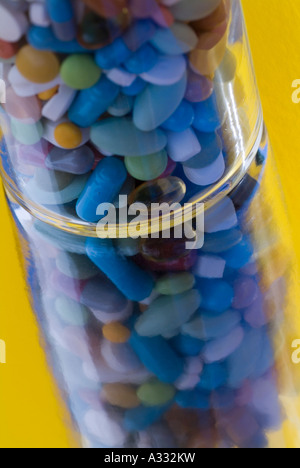 glass filled with pills in different colours and forms on a mirror Stock Photo
