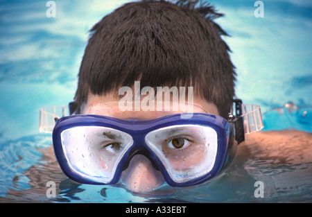 Young man wearing scuba mask and looking over the top of the water. Stock Photo