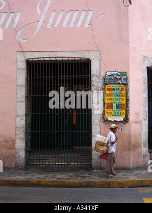 man walking past poster in the street, Merida, Yucatan, Mexico Stock Photo