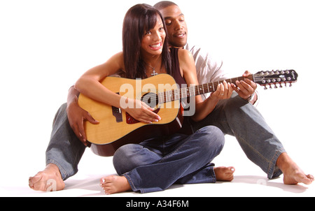 young man teaching his girlfriend how to play guitar Stock Photo