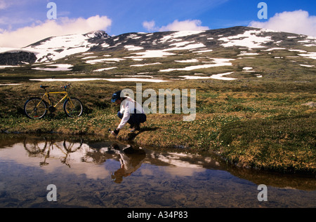 Mountain biker getting drink Hudson Bay mountain Smithers British Columbia Canada Stock Photo