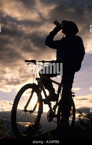 Mountain biker taking drink silhouette Smithers BC Canada Stock Photo