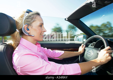 Frau mit Headset telefoniert im Auto, Woman Driving and Phoning Stock Photo