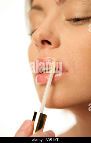 Woman applying lip gloss Stock Photo