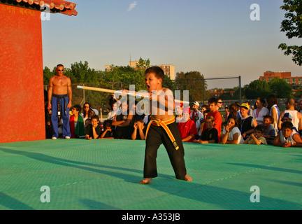 Toronto, Ontario, Canada. A boy with a wooden pole demonstrating a Karate kick on an outdoor stage before an audience. Stock Photo