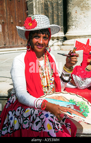 Lady holding a pipe and cigar, sitting on Cathedral steps, Plaza de la Catedral, Havana, La Habana Vieja, Cuba Stock Photo