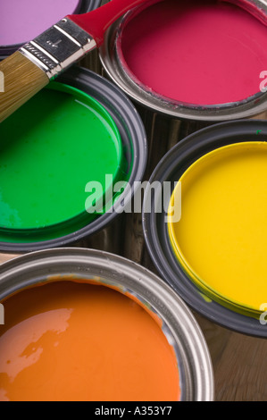 Cans full of colored paint with brush Stock Photo