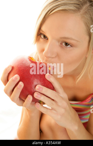 Woman eating mango Stock Photo