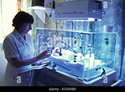Pediatric nurse monitors baby with jaundice being treated with phototherapy in an Incubator Stock Photo