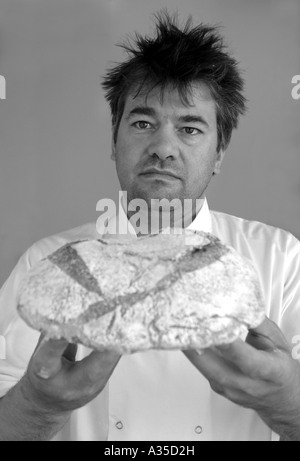 Baker holds a freshly baked loaf of bread UK Stock Photo