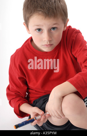 Young diabetic child injecting himself with insulin using a FlexPen Stock Photo