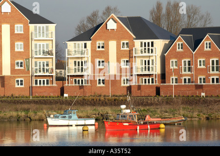 Modern apartment buildings overlooking Cardiff Bay waterfront in early morning light with moored pleasure boats Stock Photo