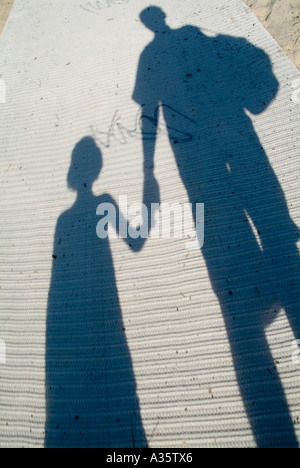 Shadow of a father and his daughter walking on a mat. Stock Photo