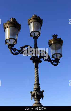 old gas street lamps now electric lights on bridge over the liffey in O Connell street Dublin vertical Stock Photo