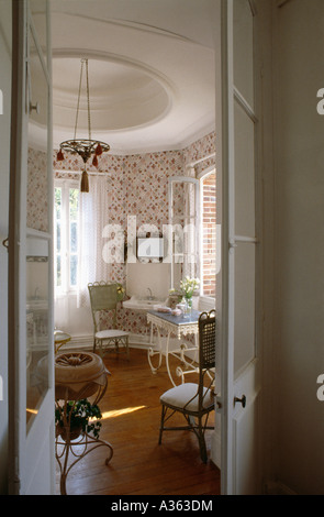 Open half-glazed doors to bathroom with floral wallpaper Stock Photo