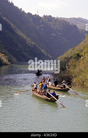 CHINA YANGTZE RIVER Tujia men suppliment their incomes by rowing and pulling their long narrow peapod boats Stock Photo