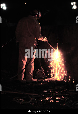 Ironworker cuts through a steel beam on the ground after the collapse of the World Trade Center in New York in 2001. Stock Photo