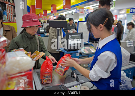 CHINA BEIJING Young Chinese woman buying prepared packaged food in Wumart an upscale supermarket in Beijing Stock Photo